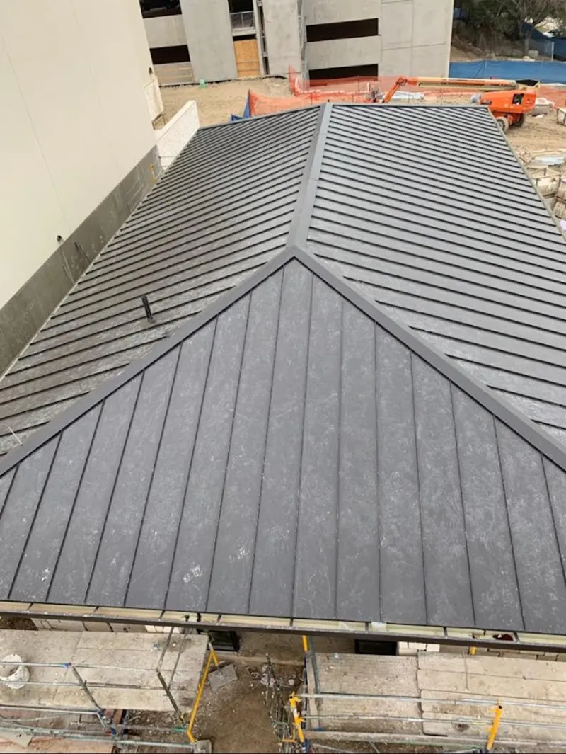 Commercial metal roof construction with crane equipment in Pilot Point